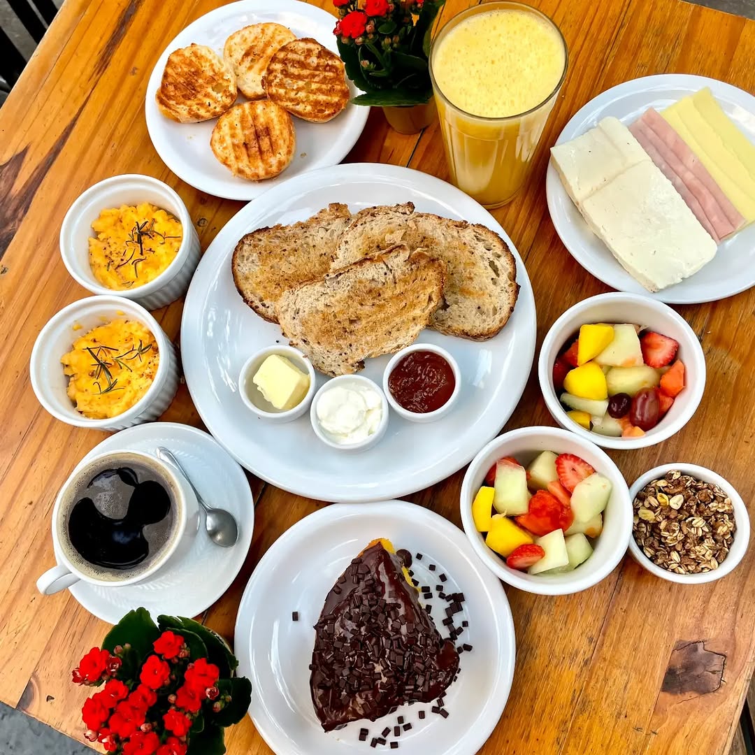 Café da manhã da PANEGIORNO com pães artesanais, frutas, café e acompanhamentos